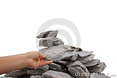 Womanâ€™s hand adding a rock to a cairn Stock Photo